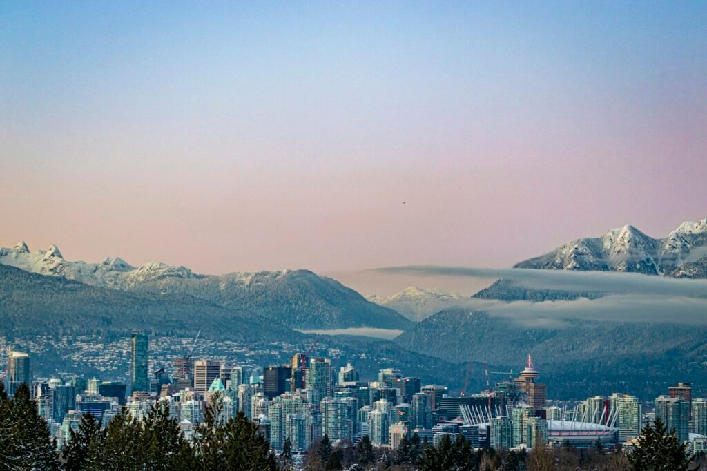 Canadian city skyline against snow-covered mountains, destination illustration